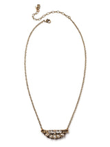 Front view of short and petite mini-bib style necklace in antique gold with teardrop pearls, rhinestone navettes, and glass bugle beads