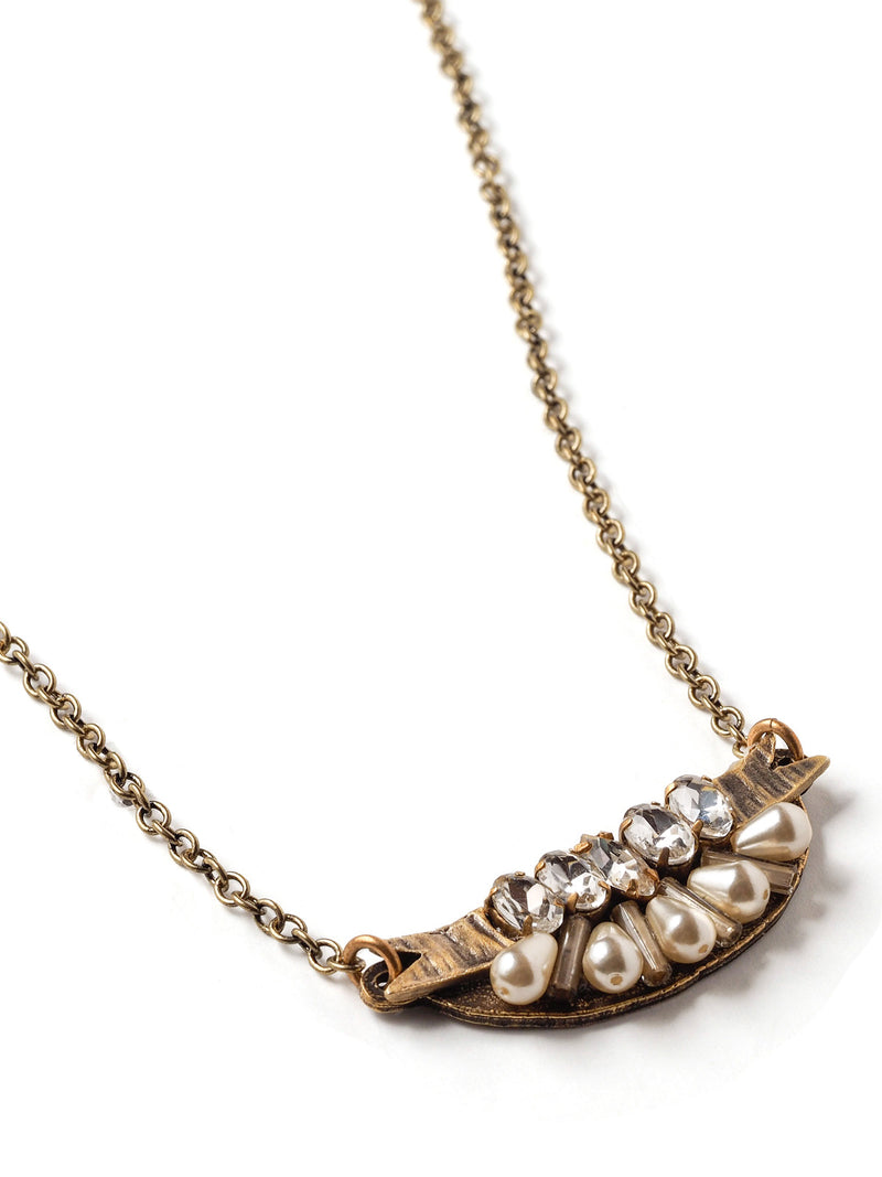 closeup view of short and petite mini-bib style necklace in antique gold with teardrop pearls, rhinestone navettes, and glass bugle beads