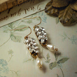 image of a pair of crystal laurel leaf earrings in a vintage, off-white, settings