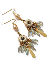 side view of a pair earrings with multiple dagger drops, pearls, and beaded appliques